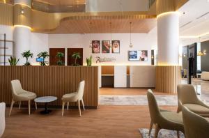eine Bürolobby mit Stühlen und einem Empfangstresen in der Unterkunft Radisson Hotel Madinah in Medina