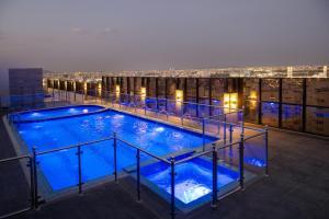 ein Schwimmbad auf einem Gebäude bei Nacht in der Unterkunft Radisson Hotel Madinah in Medina