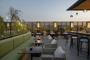 ein Restaurant mit Tischen und Stühlen und einer Bar in der Unterkunft Radisson Hotel Madinah in Medina
