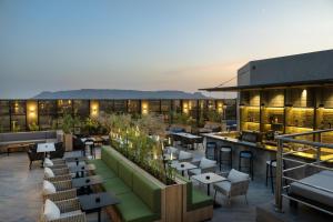 ein Hotel mit einer Dachterrasse mit Tischen und Stühlen in der Unterkunft Radisson Hotel Madinah in Medina
