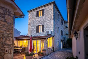 a stone building with a patio and a table at Stonehouse Ewa&Pool in Medulin