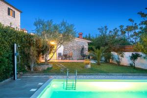 a swimming pool in the backyard of a house at Stonehouse Ewa&Pool in Medulin
