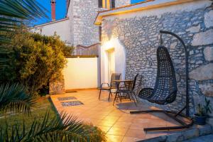 a patio with chairs and a table and a building at Stonehouse Ewa&Pool in Medulin