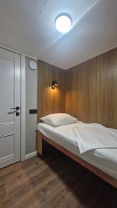 a bedroom with a bed with a wooden wall at Hostel CAPS HOME boutique in Astana