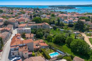 an aerial view of a town with houses and the ocean at Stonehouse Ewa&Pool in Medulin +37 photos