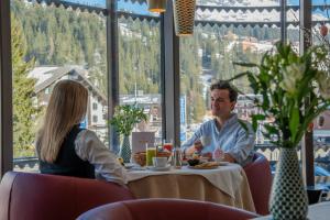 a man and woman sitting at a table in a restaurant at Post Lech Arlberg in Lech am Arlberg +101 photos