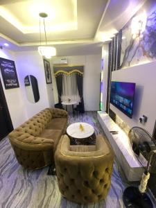 a large living room with a couch and a tv at Asika Luxe Living in Ayobo
