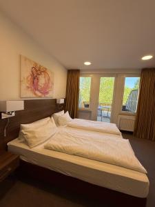 a large bedroom with two beds and windows at BSW Ferienhotel Lindenbach in Bad Ems