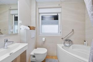 a white bathroom with a toilet and a sink at House AGAPE near Zagreb with rooftop jacuzzi in Kerestinec +43 photos