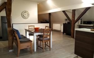 a kitchen with a table and chairs and a clock at Ferienwohnung auf Vierseitenhof in Senftenberg +13 photos