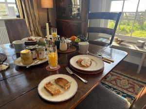 a wooden table with plates of food on it at Cottage on remote wild coast in Bawdsey