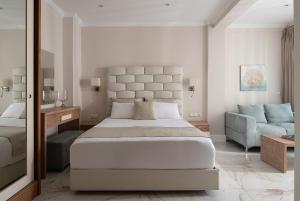 a bedroom with a large bed and a couch at La Mer Escape in Nikiti