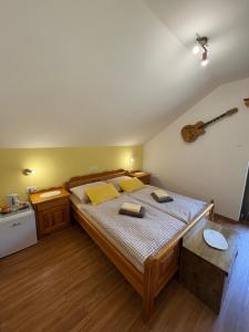 a bedroom with a large bed and a guitar on the wall at Turistična kmetija Čerček in Solčava