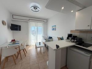 a kitchen and living room with a table and chairs at Nautilus City Studios & Apartments in Rhodes Town