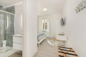 a white room with a bed and a desk with a television at B&B Il Connubio - Rooms & Apt between Florence and Chianti in Impruneta +47 photos