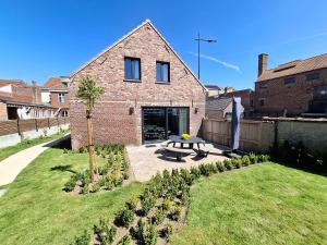 a brick house with a picnic table in the yard at Huyze Basco in Poperinge