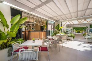a restaurant with tables and chairs and plants at Occidental Puerto Banús in Marbella