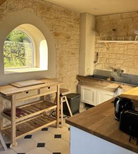 a kitchen with a counter and a window in a room at Le Grand Clos Marçon in Marçon