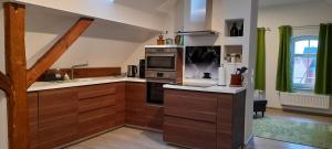 a kitchen with wooden cabinets and a stove top oven at Ferienwohnung auf Vierseitenhof in Senftenberg