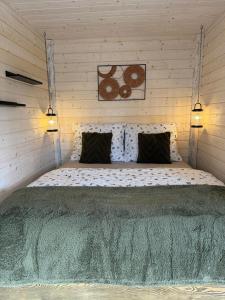 a bedroom with a large bed in a wooden wall at Treetop Tiny House Pod Korunami in Horná Mičiná