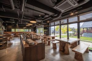 a restaurant with wooden tables and benches and windows at Always Niseko in Kutchan