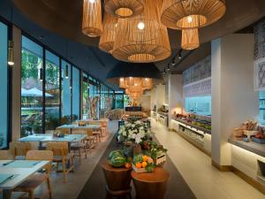 a restaurant with tables and chairs and chandeliers at GreenLa by Villacarte in Layan Beach