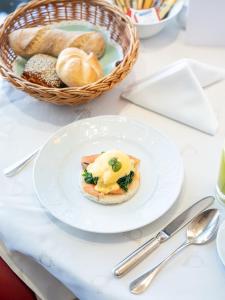 a plate of food on a table with a basket of bread at Post Lech Arlberg in Lech am Arlberg