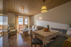 ein Wohnzimmer mit einem Tisch und einem Sofa in der Unterkunft Pension Straifhof in Brixen im Thale