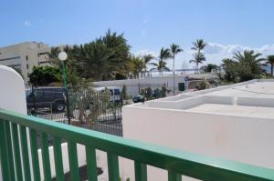a balcony with a view of a parking lot with palm trees at Apartamentos Guanarama in Puerto del Carmen