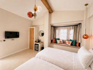 a bedroom with a bed and a tv and a window at Studio Miscela in Urla