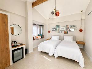 two beds in a room with a fireplace and a tv at Studio Miscela in Urla