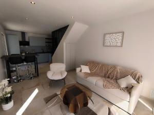 a living room with a couch and a table at Hôtel Du Viaduc in Tarascon