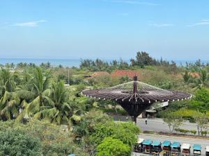 a view of a resort with a large umbrella at Sen Biển Hotel Luxury Sầm Sơn in Sầm Sơn