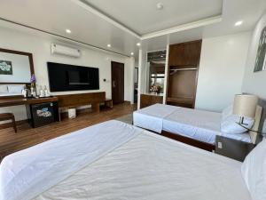 a hotel room with two beds and a flat screen tv at Sen Biển Hotel Luxury Sầm Sơn in Sầm Sơn