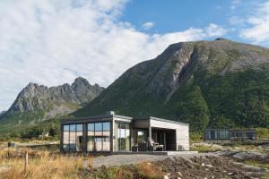 a house in front of a mountain at Lyngvær Sunrise Lodge - Hot tub - No 11 in Storøya