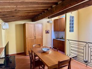 a kitchen and dining room with a wooden table and chairs at Nido in Toscana - Appartamento in Centro Storico con Aria Condizionata in Buonconvento