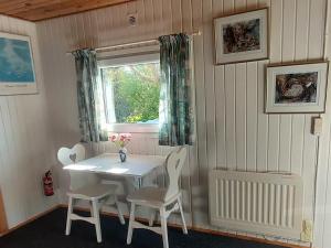 a white table and chairs in a room with a window at Gæstehus Stillinge Strand in Stillinge Strand