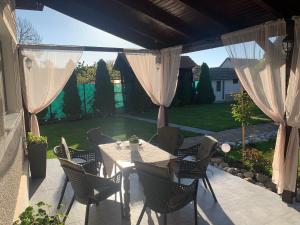 a patio with a table and chairs and a garden at CASA LUI MOȘU in Alba Iulia