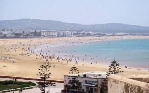 a group of people on a beach near the water at Appartement Moderne à coté de la plage - Essaouira in Essaouira