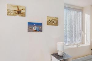 a room with three pictures on the wall and a window at Chambre d'hote chez Odile in Plougoulm +21 photos