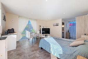 a bedroom with a bed and a kitchen and a table at Chambre d'hote chez Odile in Plougoulm