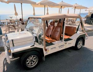 a golf cart parked next to the ocean at Hôtel Gabriel in Menton