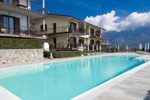 a large swimming pool in front of a building at Residence Primera Rompala, GTSGroup in Tignale