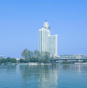 un grande edificio in mezzo a un grande corpo d'acqua di Shu Guang International Hotel a Nanjing