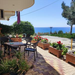 a patio with a table and chairs and flowers at Serene Vintage in Nea Moudania