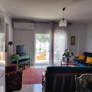 a living room with a couch and a table and a window at Serene Vintage in Nea Moudania