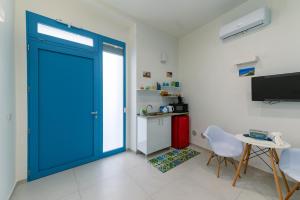 a blue door in a room with a table and a kitchen at Sale e Salsedine in Bari
