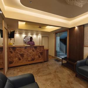 a man standing at a counter in a hotel lobby at Sienna Suites in Navi Mumbai
