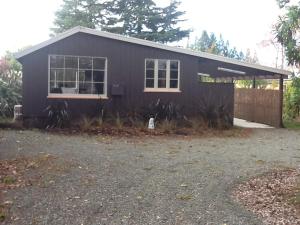 a black house with a fence in front of it at Thyme On The Terrace in Te Anau +2 photos