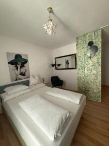 a bedroom with a large white bed and a chandelier at Apartments Ars Vivendi in Trogir